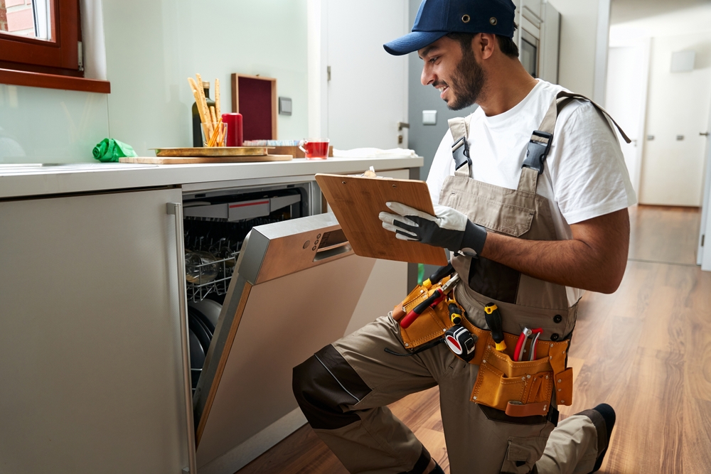 Handyman inspecting appliance installation with checklist clipboard