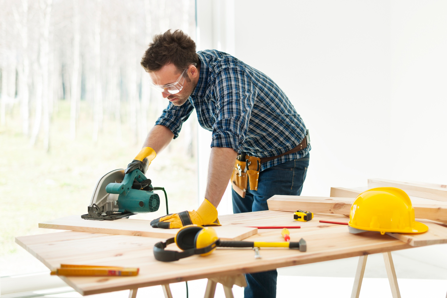 Skilled carpenter using circular saw on wood panels