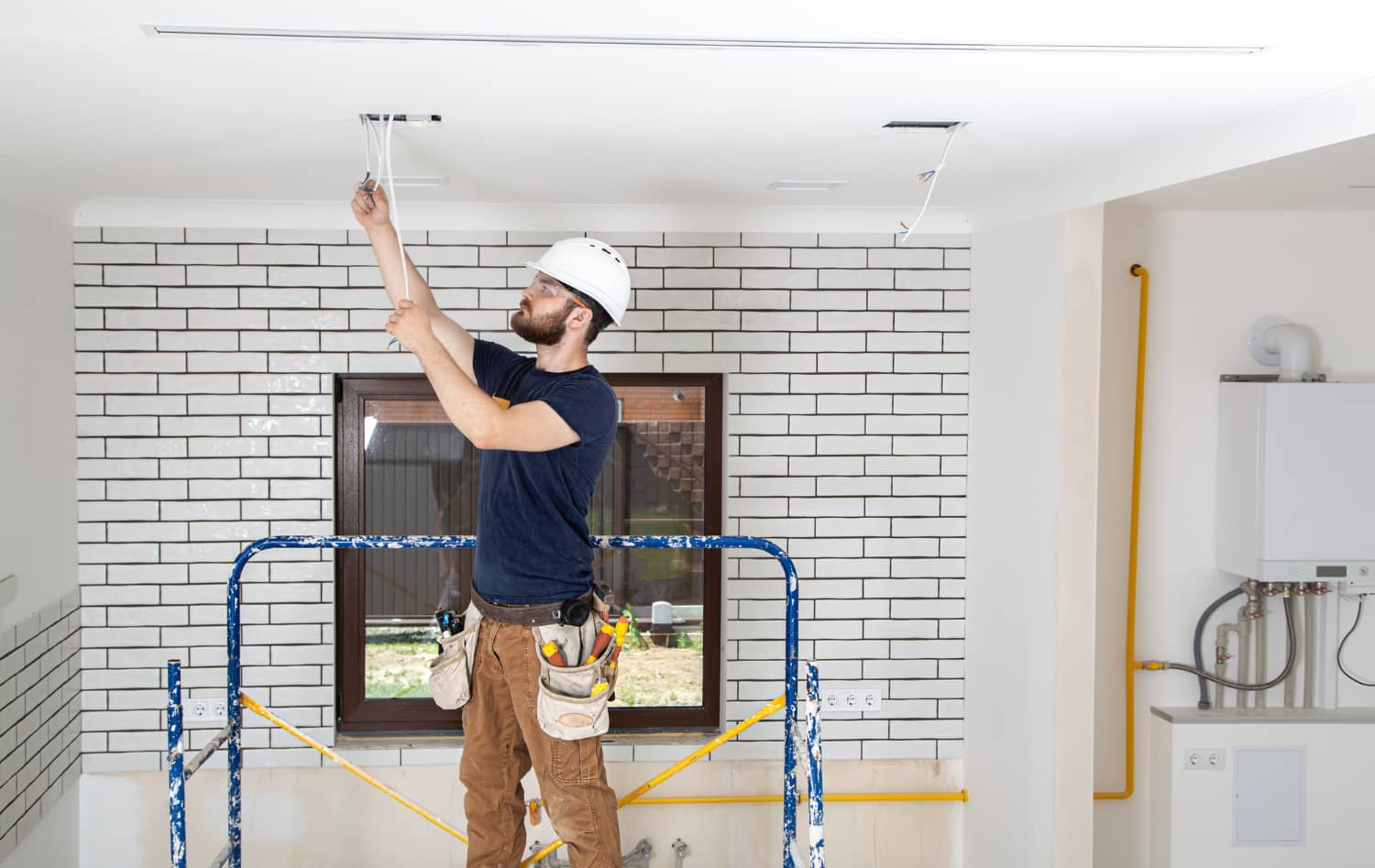 Construction worker on scaffolding completing renovation work